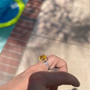 White gold diamond ring with a big yellow sapphire.